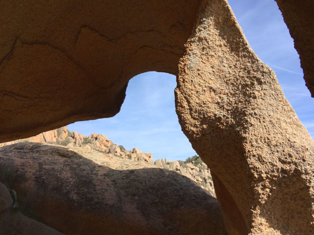 Natürlicher Felsbogen aus Granit mit Blick in den blauen Himmel am Initiationsplatz.