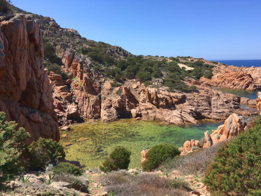 Geschützte Bucht mit mediterraner Vegetation und ruhigem Meer.