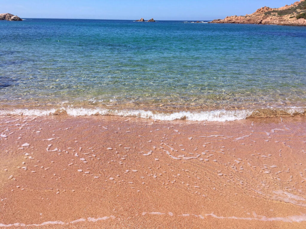 Ruhiges Meer mit transparentem Wasser am naturbelassenen Strand Sardiniens.